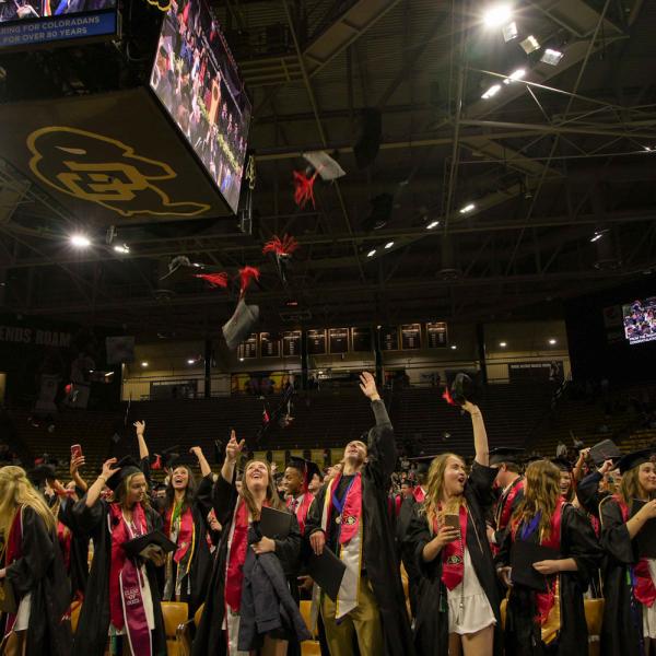 CMCI graduates toss their caps.