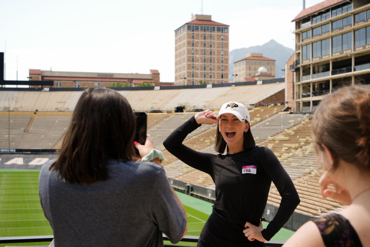 Student taking photo of another student in folsom field