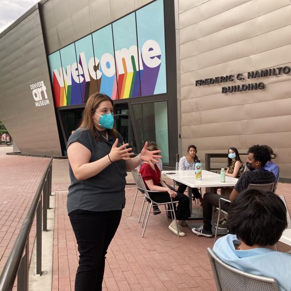 Yesenia Robles, Chalkbeat Colorado’s suburban reporter, speaks about the advertising industry to incoming CMCI students outside of the Denver Public Library.