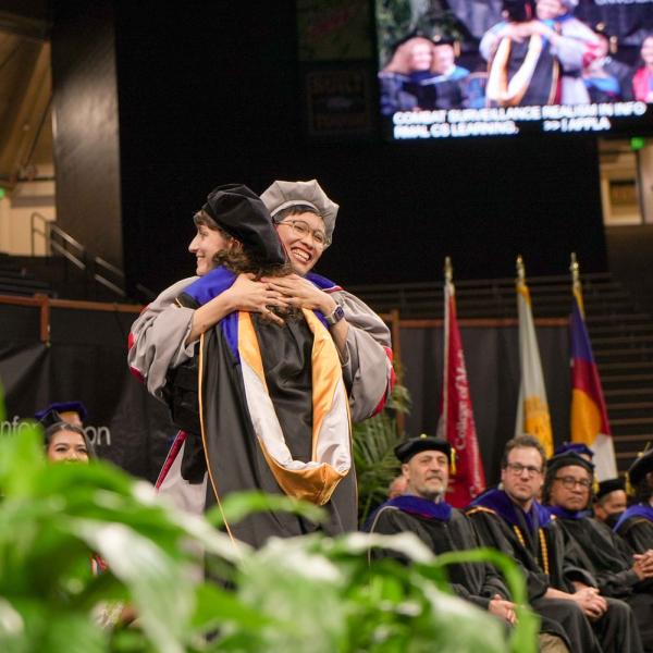 Assistant Professor Ricarose Roque congratulates a graduate student she advised.