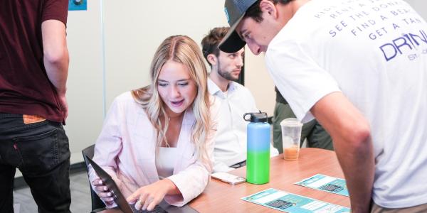 Two students gather around a computer