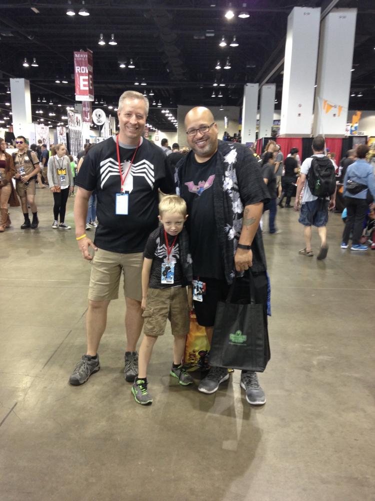 Stevens and CMCI alumnus Christopher Bell pose with Stevens’ son after Bell was awarded the Popular Culture Educator of the Year award in the higher education category.