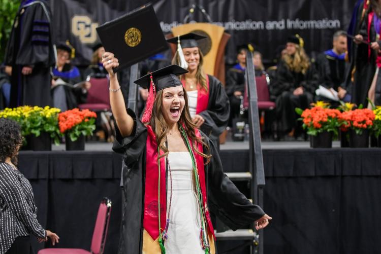 CMCI Undergraduate student holds up her diploma cover
