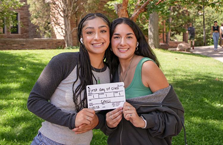 Two female first-year students pose outdoors on their first day of class.