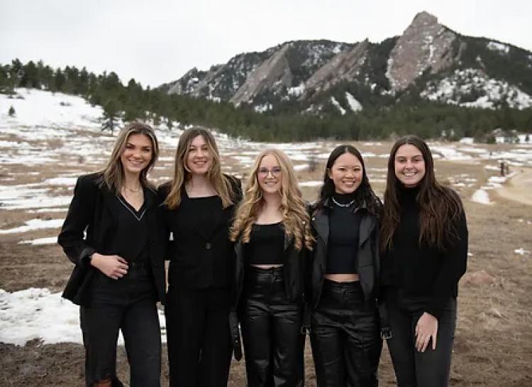 A group of female students in front of the Flatirons.