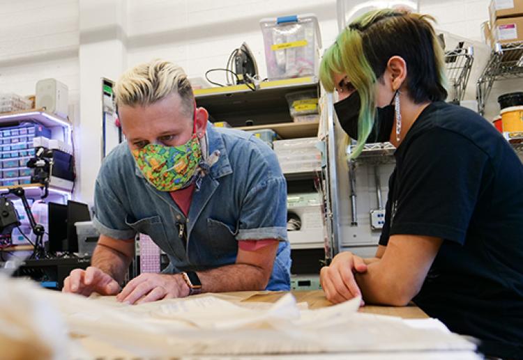 Steven Frost works with a student during a workshop for the Slay the Runway event.