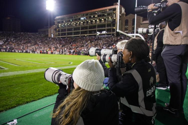 Angel Mollel taking photos at a CU Buffs Football game