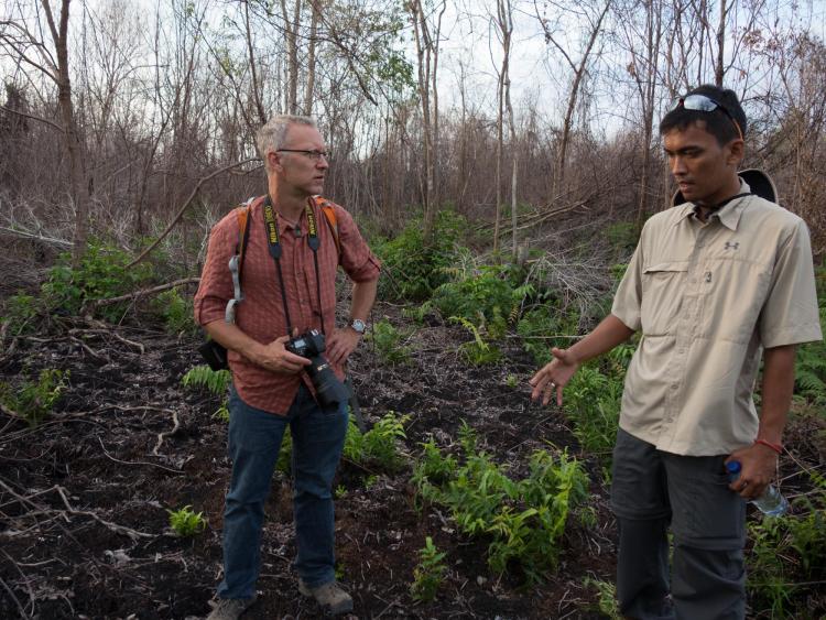 Michael Kodas (left) interviews an Indonesian environmental activist during one of his reporting trips to Sumatra and Borneo in 2014.