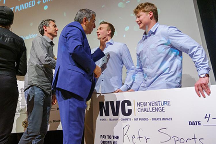 Two judges speak with two members of Refr following their scond-place finish at NVC.