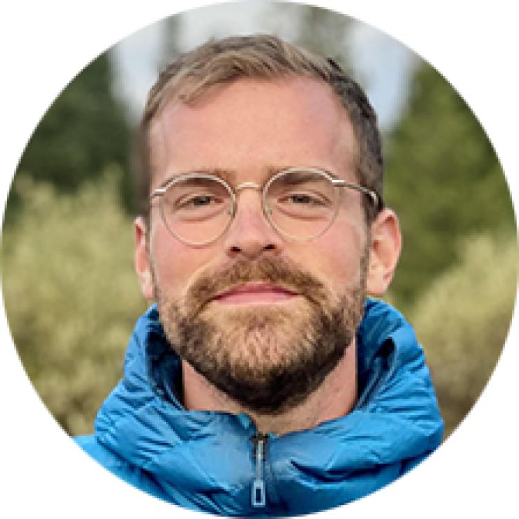 Headshot of Luke Runyon wearing outdoor gear in the backcountry.