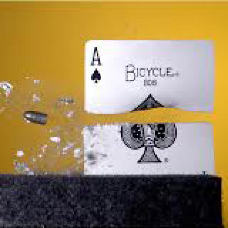 A playing card being split with a bullet