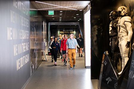 A CU staff member leads a tour through the corridor of the Folsom Field stadium.
