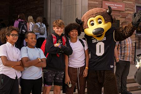 Chip, the mascot poses with a group of high schools students.