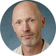 Headshot of Tim Kuhn against a blank background.