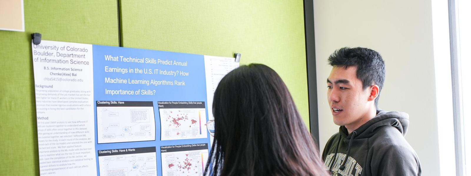 Students looking at info graphic at a showcase