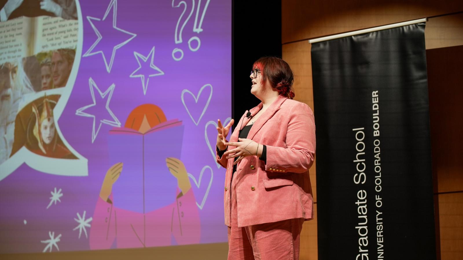 A PhD student presents onstage at the 3-Minute Thesis competition.