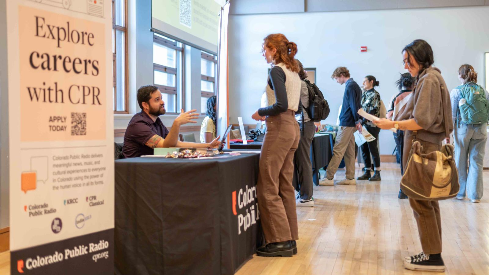 Students lined up to speak with a recruiter during a career fair.