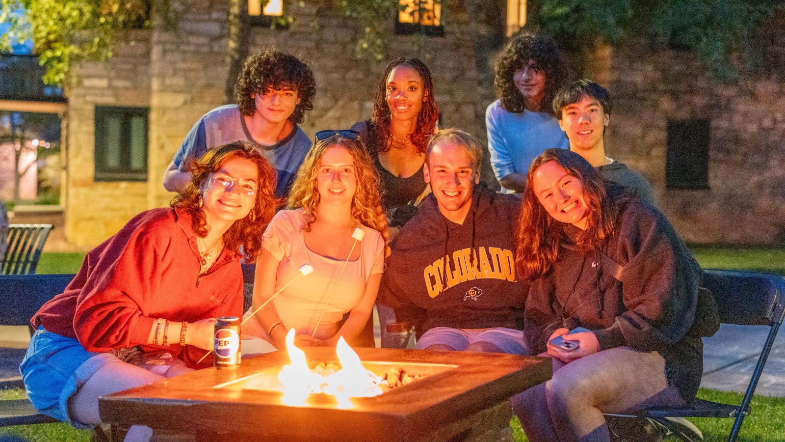 Students around a fire pit on campus.