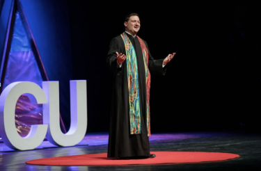dylan doyle standing on ted talk stage