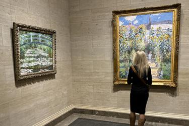 A female student examines a painting in the National Gallery.