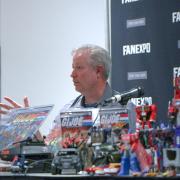 Rick Stevens speaks at a conference table, surrounded by GI Joe and Transformers action figures.