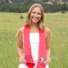 Henley Beisert stands at the Colorado Chautauqua wearing a white dress and red CMCI graduation sash.