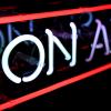 An on air sign lighted in a darkened room.