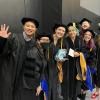 Graduate students pose for a photo before graduation.