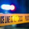 A crime scene with tape and flashing police lights.