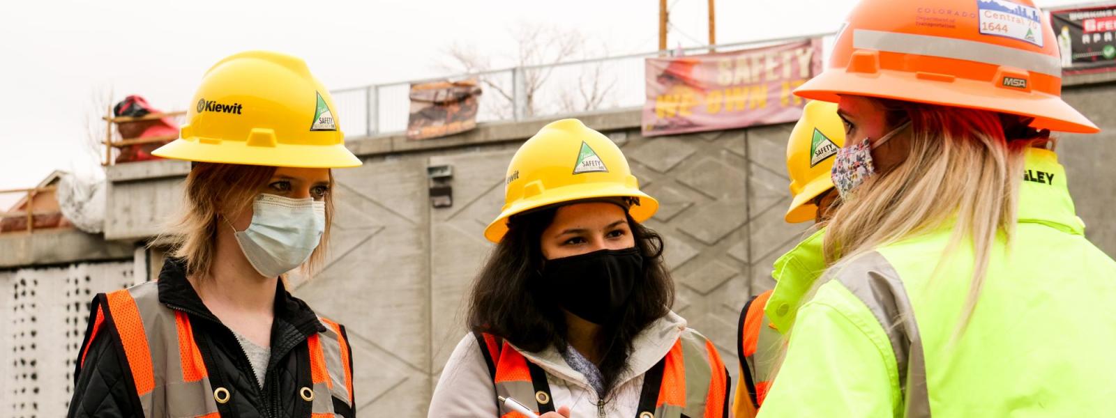 Journalism students interviewing at a construction site. 
