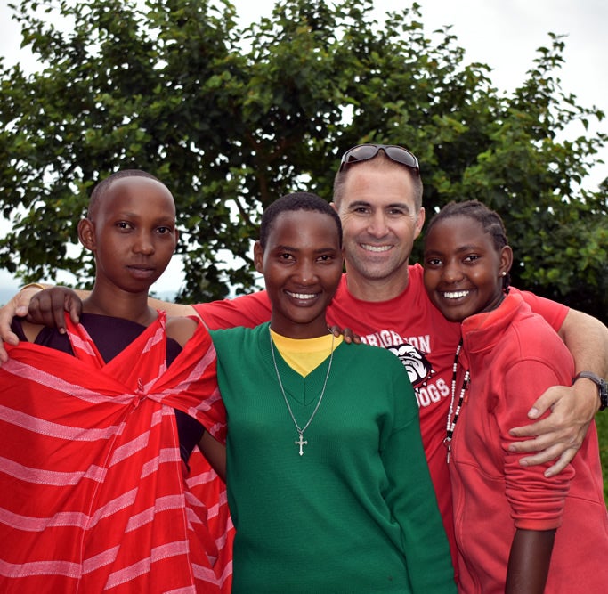 Tony Matteroli, who adopted Mollel in 2014, poses with Mollel and two of her sisters. 