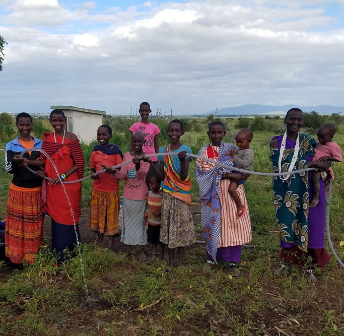 Maasai people show off their new water supply in 2015, one of Mollel’s proudest achievements made possible through her 1 Love foundation. 