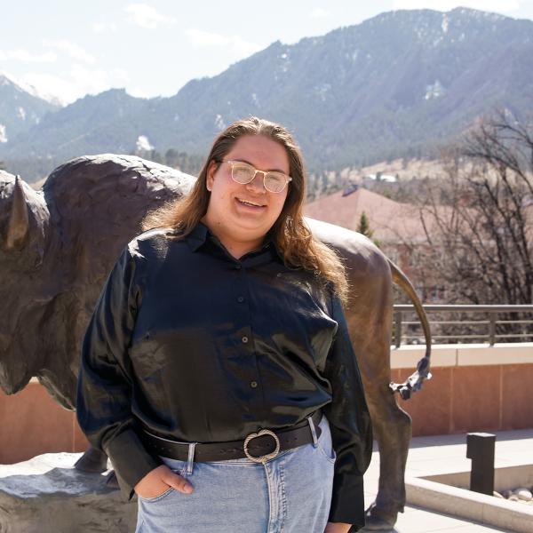 Nic Tamayo with a buffalo statue and the Flatirons in the background.