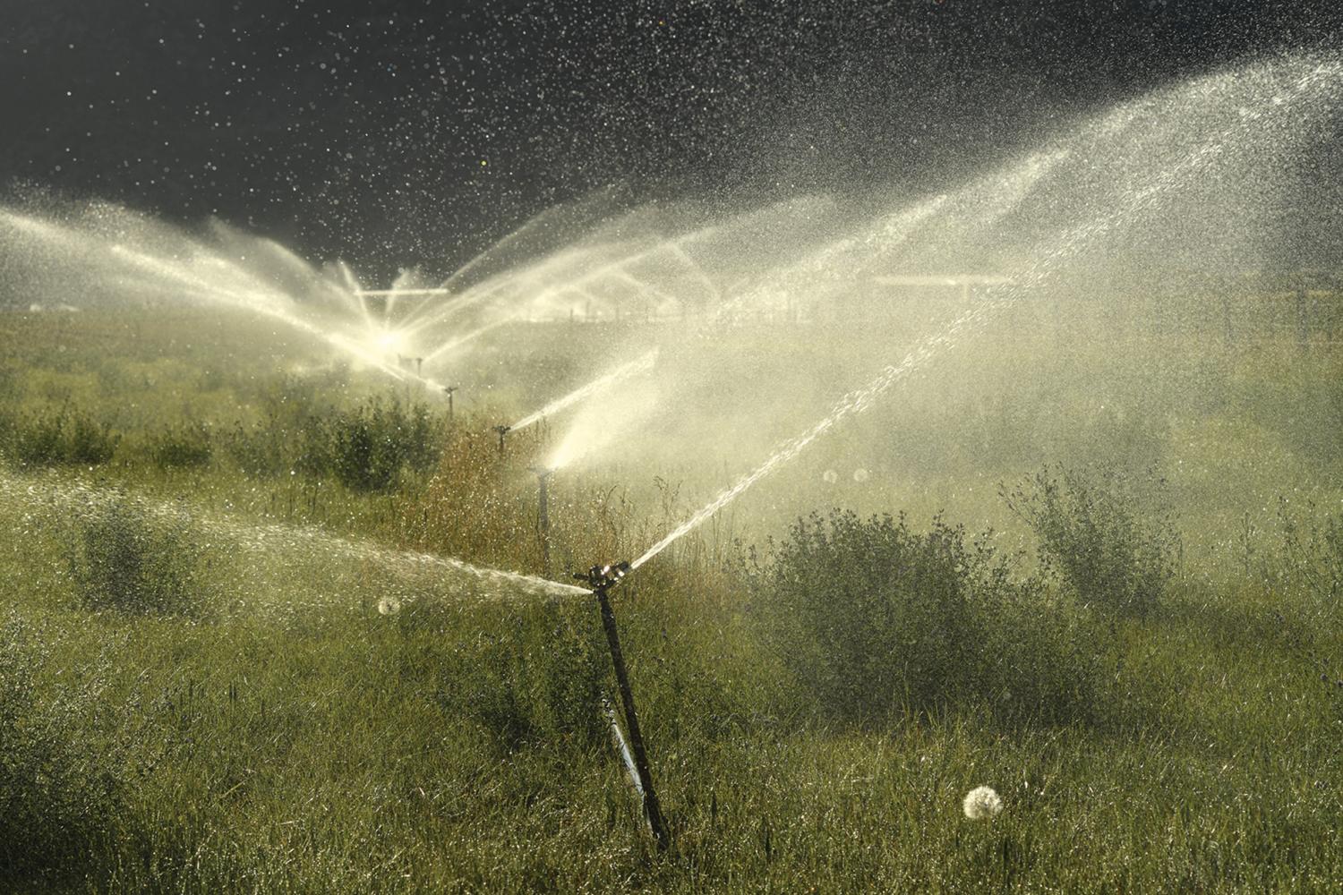 Large rotating sprinklers water a field in Paragonah, Utah, that's used to grow feed for livestock. While new irrigation methods can offer less evaporation and water waste, many small farms and ranches cannot afford to make these updates.