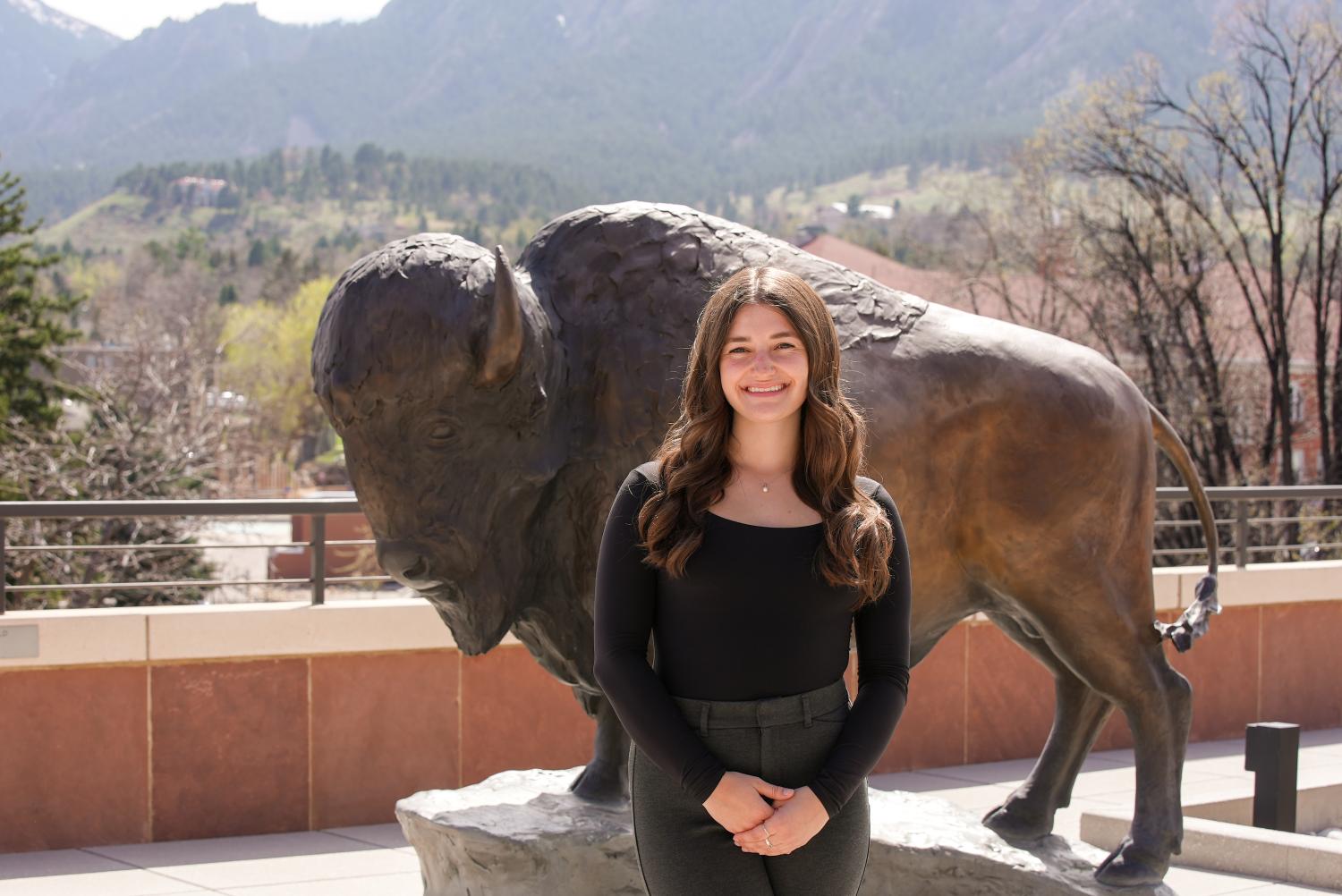 Graduate Sarah Carleo in front of the CASE buffalo statue