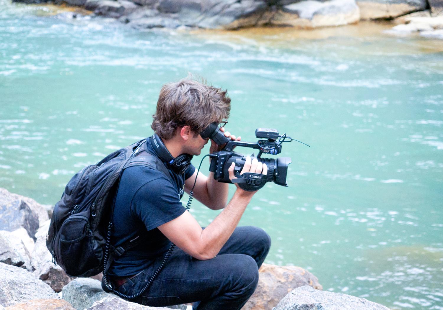 A student films the water.
