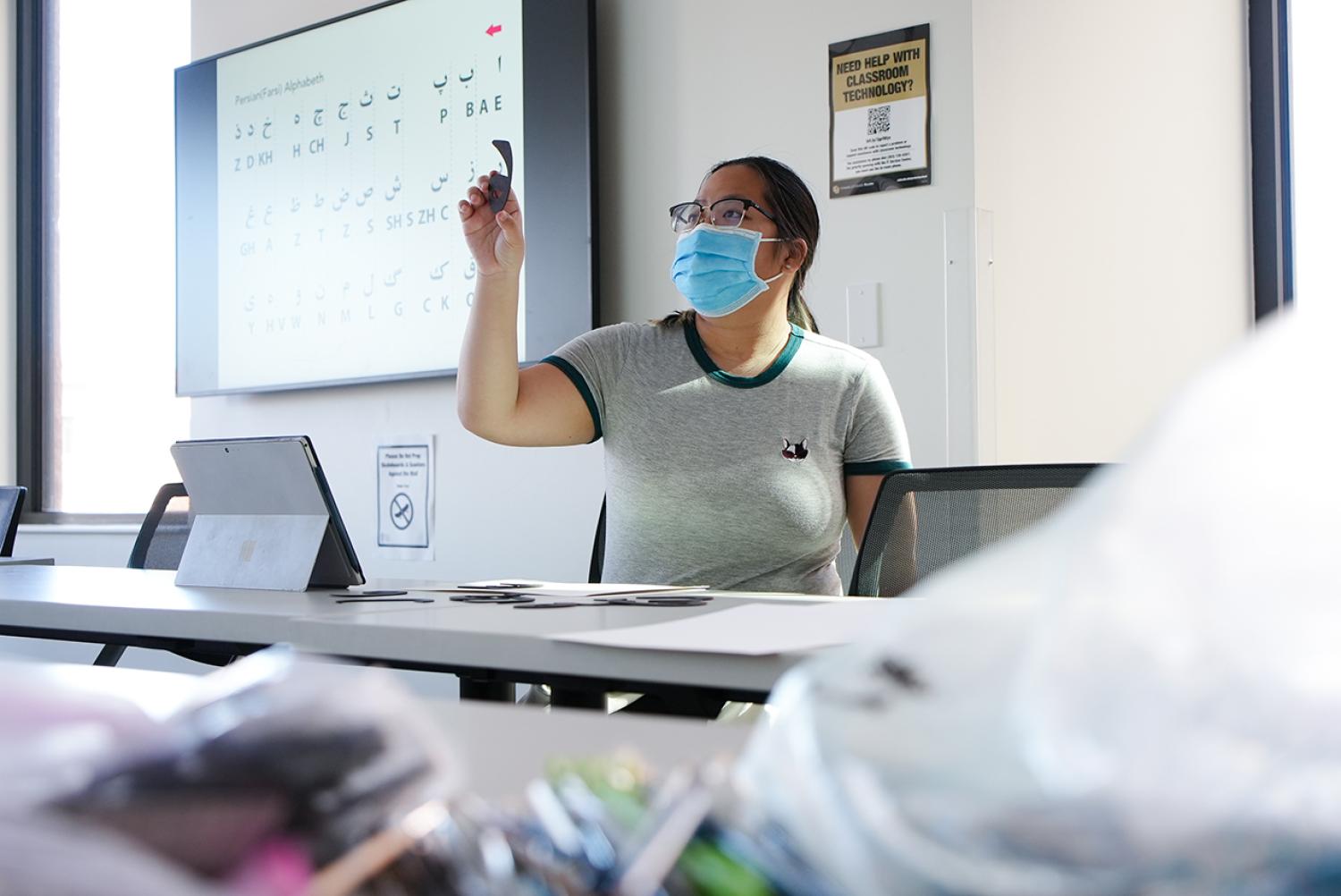 A Design Club student creates calligraphy during a design workshop, called Persian Typography Through Zar Font, led by instructor Parisa Tashakori on April 8, 2022.