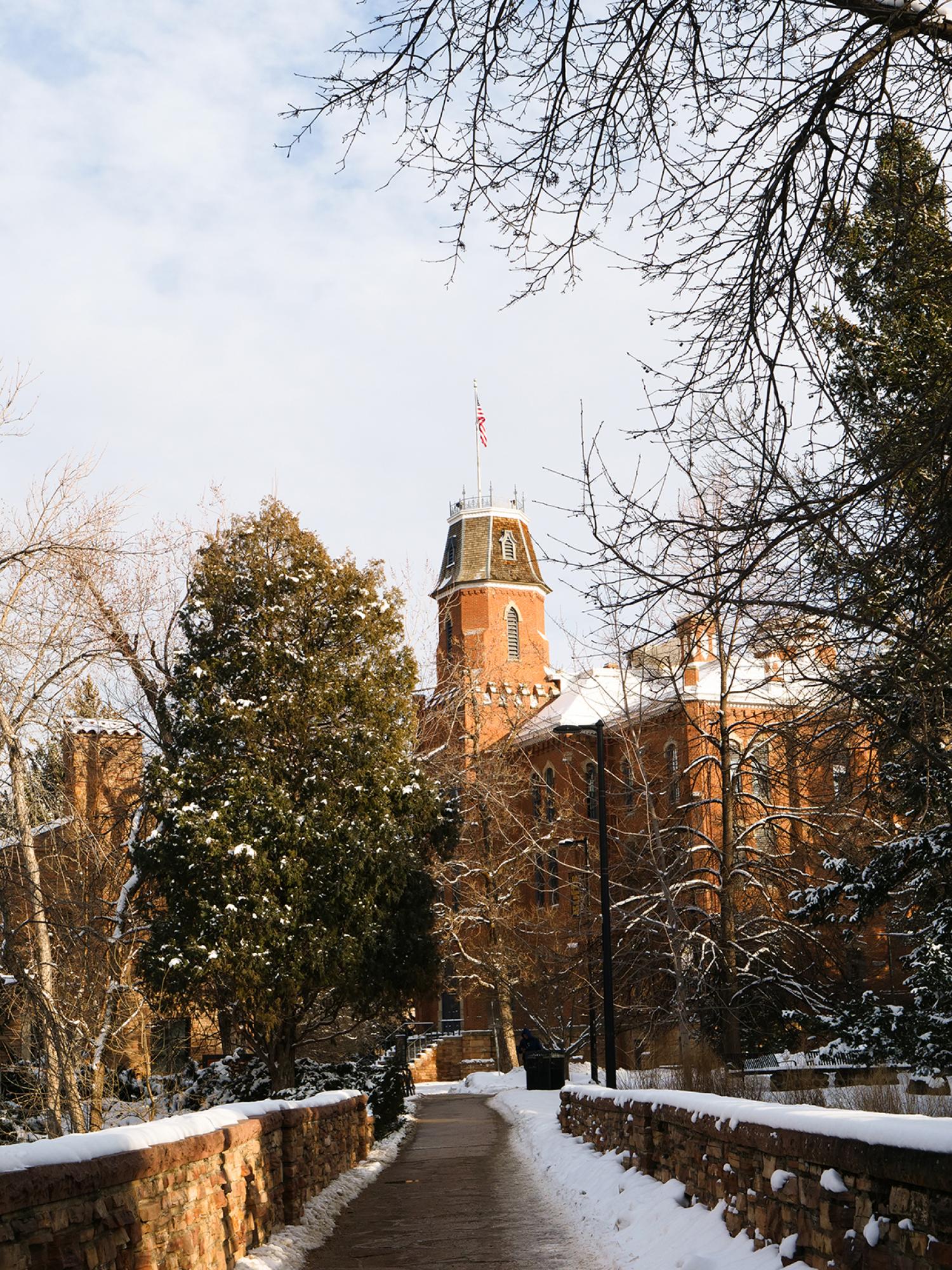 Fresh snow falls in front of Old Main, the oldest building on campus and the location of the University of Colorado’s first journalism classes. In 1922, the university created the Department of Journalism, which is celebrating its centennial anniversary this year.