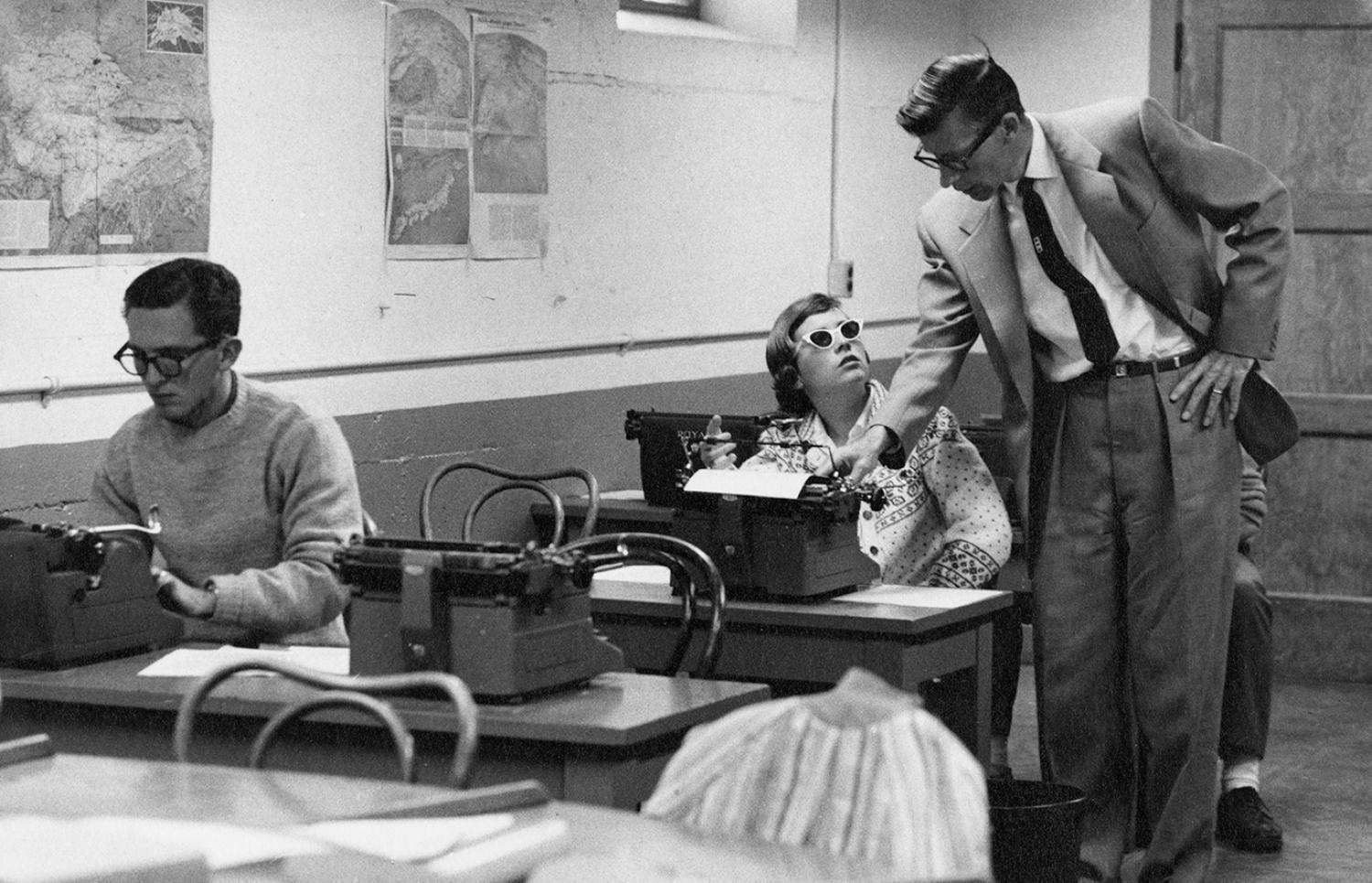 Students in the School of Journalism work on typewriters, pull feed from news wires, consult with faculty and develop photos in darkrooms, dates unknown. Source: University Libraries Rare and Distinctive Collections