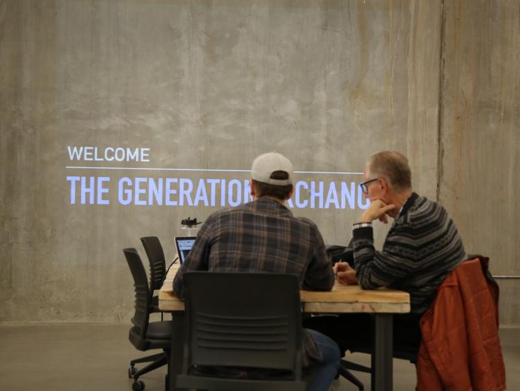 Cole Gendelman (CompSci’18) works with local retiree Jeffrey Peacock to organize and back up photos as part of the Generation Exchange Technology Workshop, held last spring at CMCI Studio in downtown Boulder.