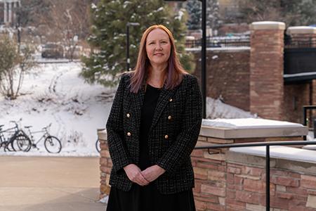 A student in professional attire poses on the CU Boulder campus.