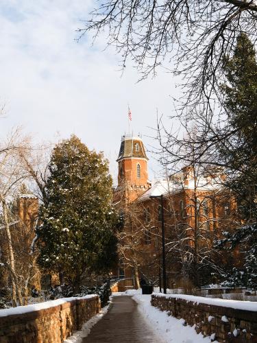 Fresh snow falls in front of Old Main, the oldest building on campus and the location of the University of Colorado’s first journalism classes. In 1922, the university created the Department of Journalism, which is celebrating its centennial anniversary this year.