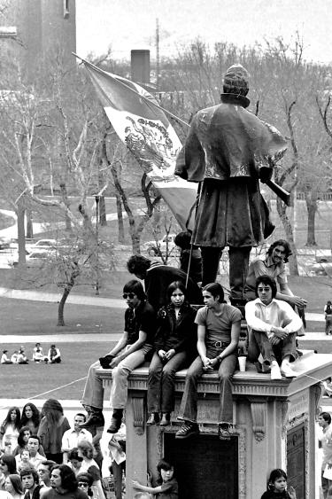 Protesters sit on a Civil War monument in front of the Colorado State Capitol during a Chicano civil rights demonstration in Denver on March 17, 1974.