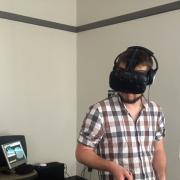 Student uses a virtual reality headset and handsets.