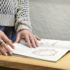 hands examining a folder of an ENVD Latin honors recipient's work