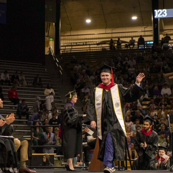 Graduate Max Gannett walks across the stage.