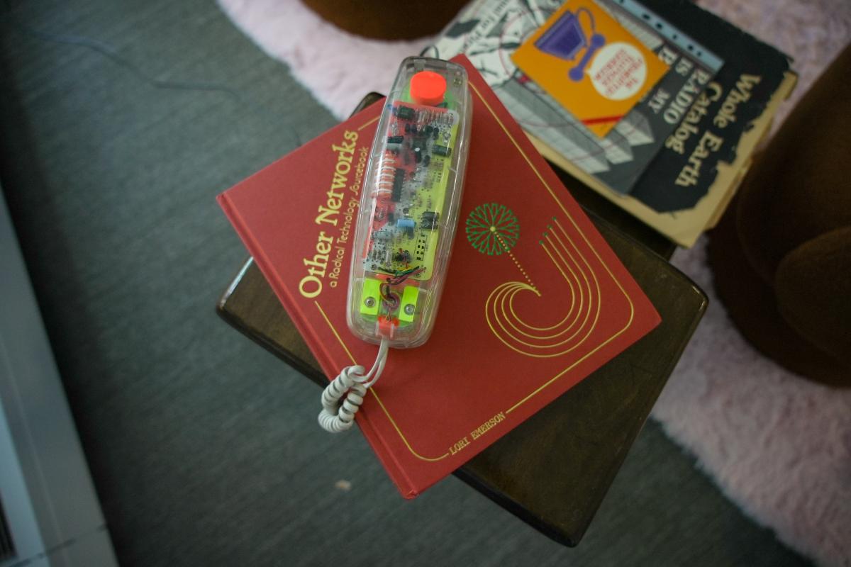 A classic clear phone handset sits on top of a book