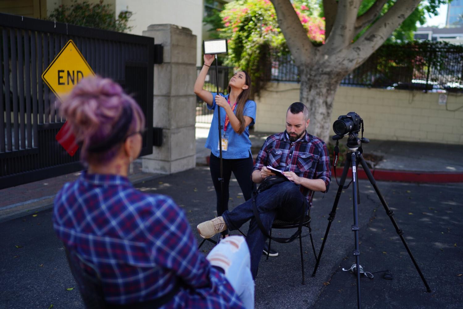 Tessa Diestel adjusts the lighting while she and Brendan Campbell prepare to interview Maria Roman, a board member of the TransLatin@ Coalition and friend of Viccky Gutierrez. Photo by Angel Mendoza.