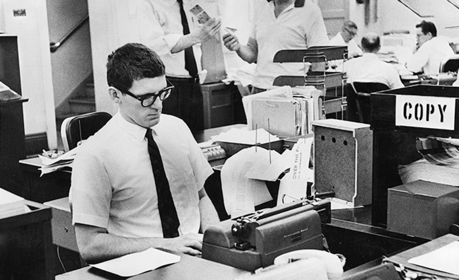 Students in the School of Journalism work on typewriters, pull feed from news wires, consult with faculty and develop photos in darkrooms, dates unknown. Source: University Libraries Rare and Distinctive Collections