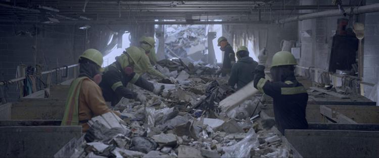 Image still from film In Excess featuring workers going through trash delivered to Haiti from Philadelphia